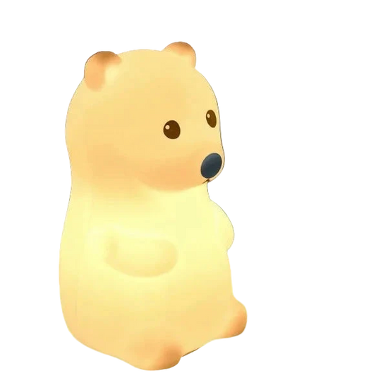 Bear-shaped night light emitting a warm glow on a dark background